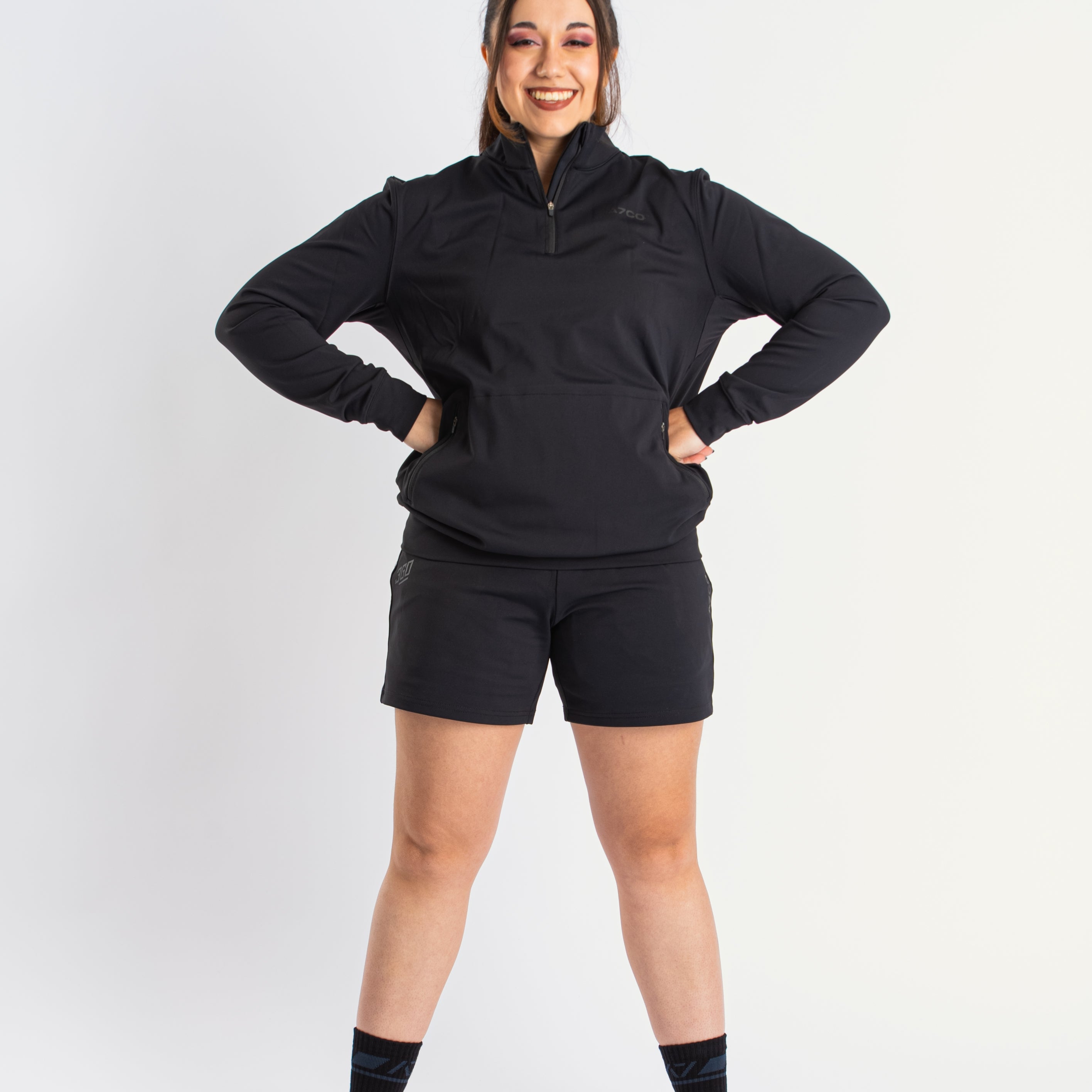 Athlete wearing the a7-us.mombra Quarter Zip Jacket in Stealth, demonstrating fit and style in a gym setting.