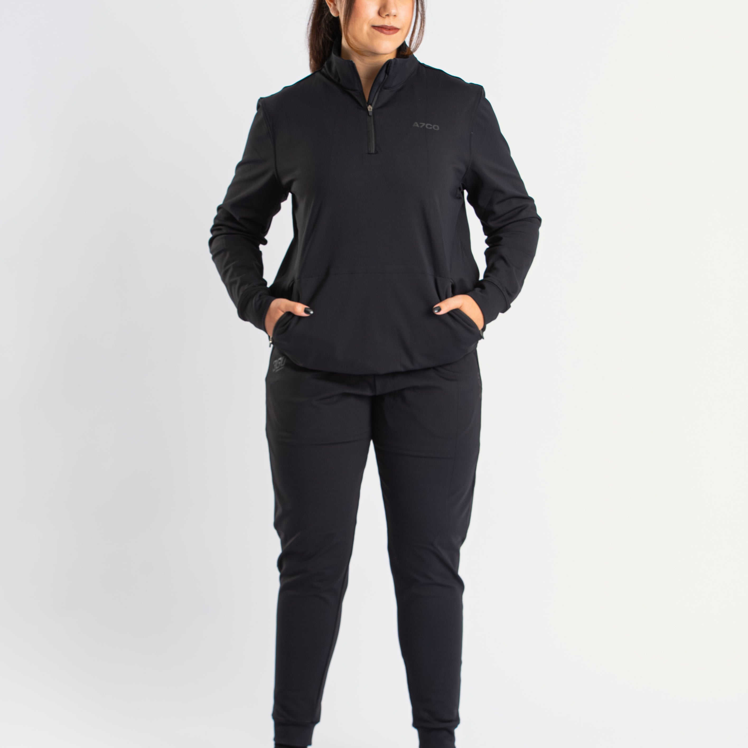 Athlete wearing the a7-us.mombra Quarter Zip Jacket in Stealth, demonstrating fit and style in a gym setting.