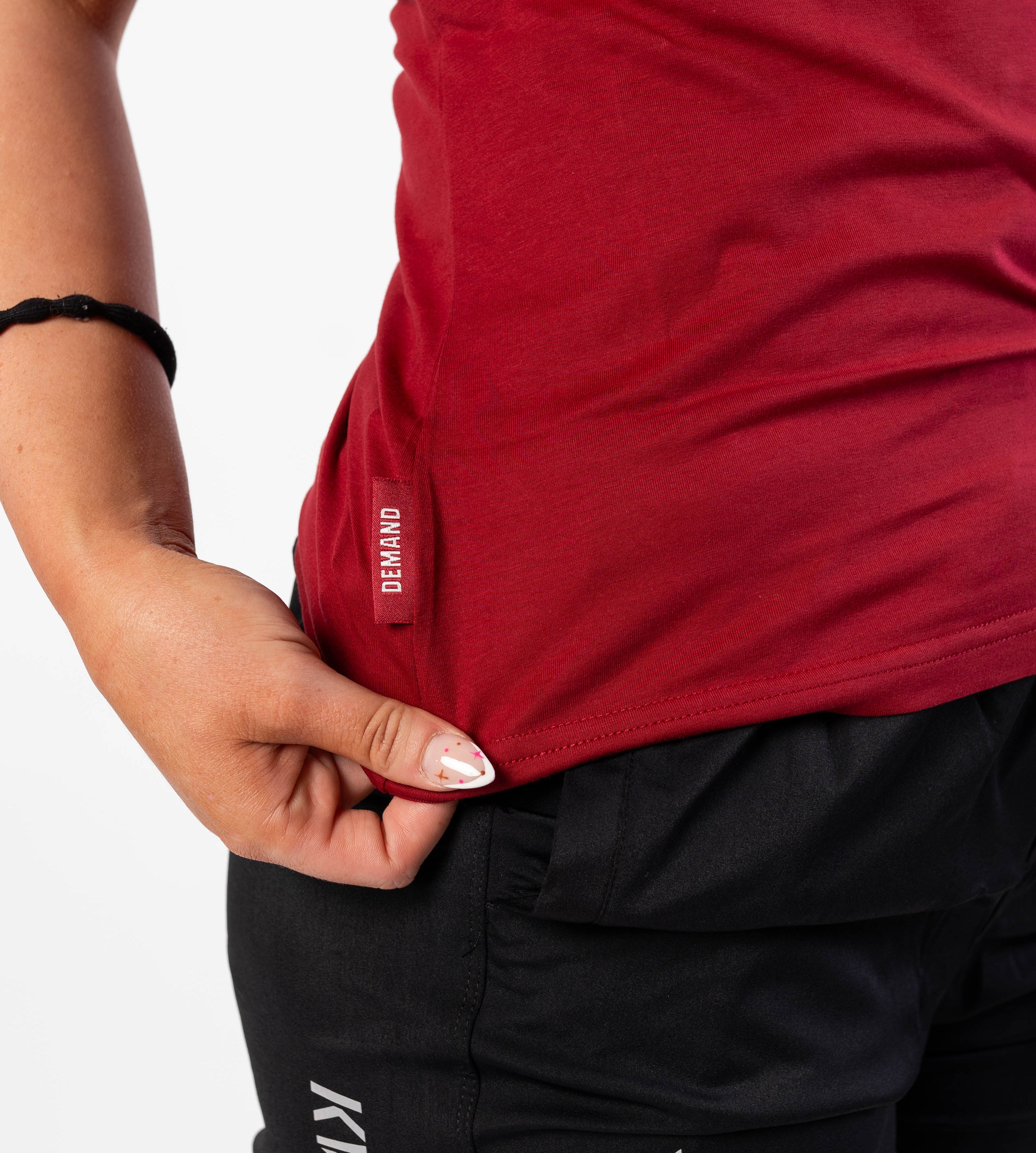 Side Hem Tag on Women's Meet Shirt with Demand Greatness text on the hem tag