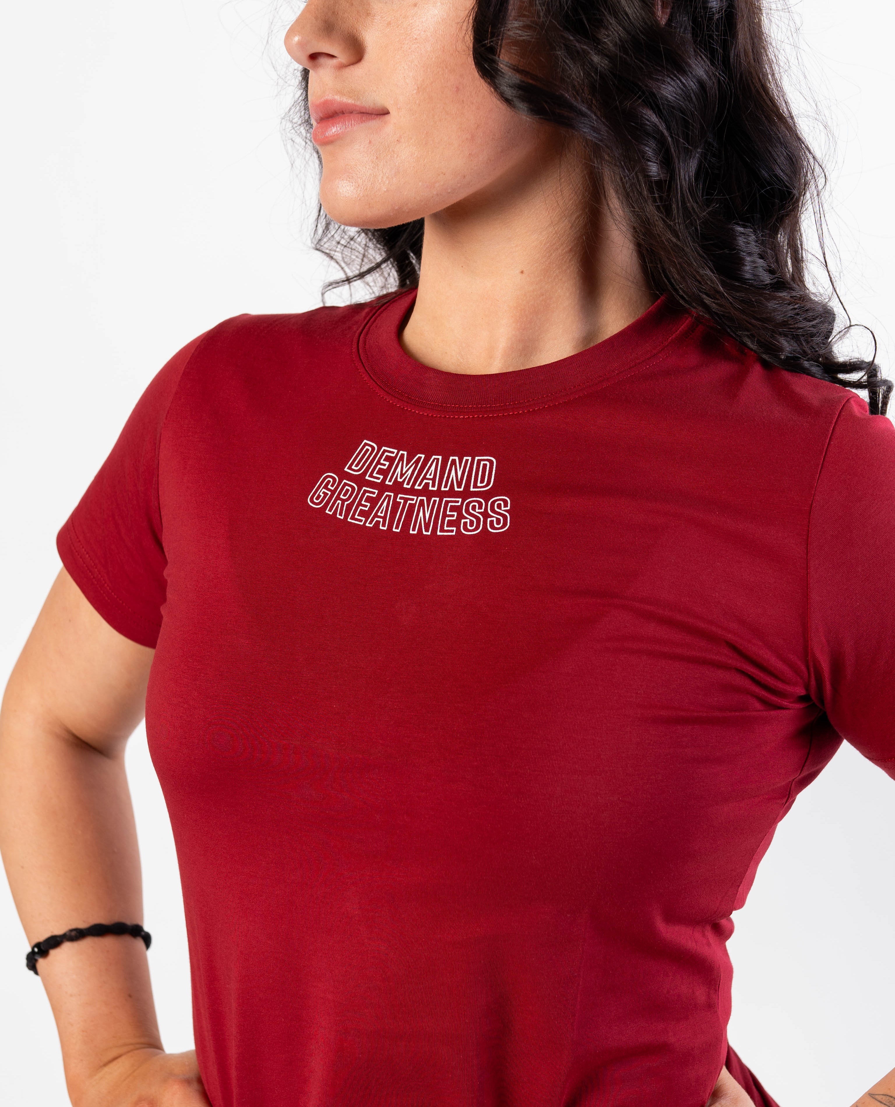 Close up of DEMAND GREATNESS text on the top of center chest of meet shirt to show underneath singlet