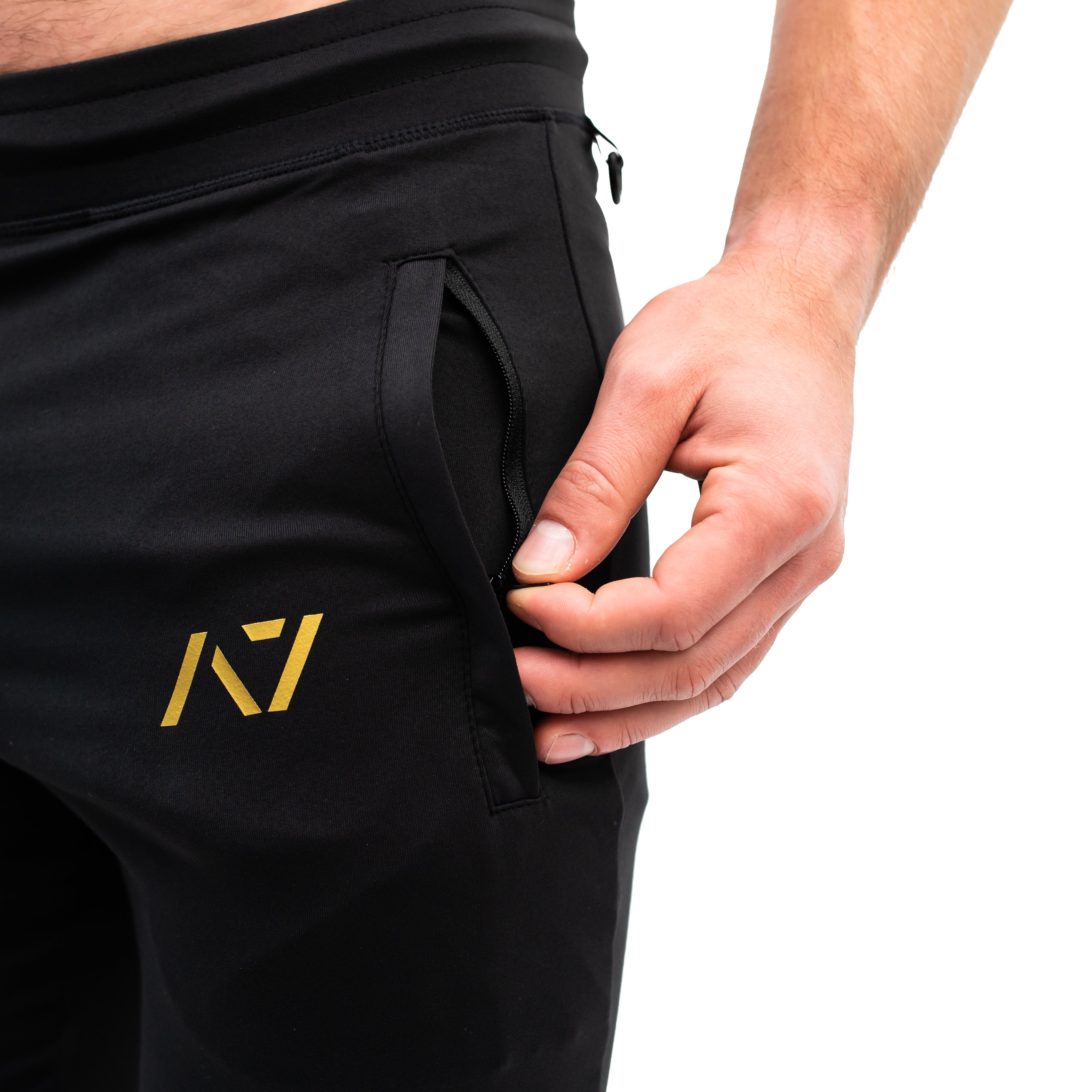 Close-up of the zippered front pocket on the Gold Standard Defy Joggers, showcasing the matte zipper and soft stretch fabric for secure, streamlined storage.