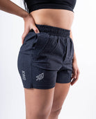  Side profile of A7 360Go 1Z KWD Shorts in Stealth/Shadow, highlighting the wide waistband with drawstrings and A7-branded aglets.
