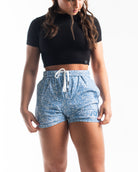 Front view of A7 360Go 1Z KWD Shorts in Slate Blue, showing clean athletic fit, built-in liner, and matte silicone A7 logo on women.