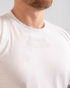 Close up of Demand Greatness text on the top of the chest on the front of the meet shirt