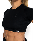 Person wearing a black athletic outfit with a visible brand logo on a white background