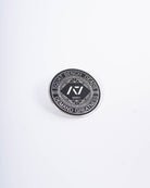Front view of A7 Revive Pin featuring raised enamel design in black with symbolic crest detailing.
