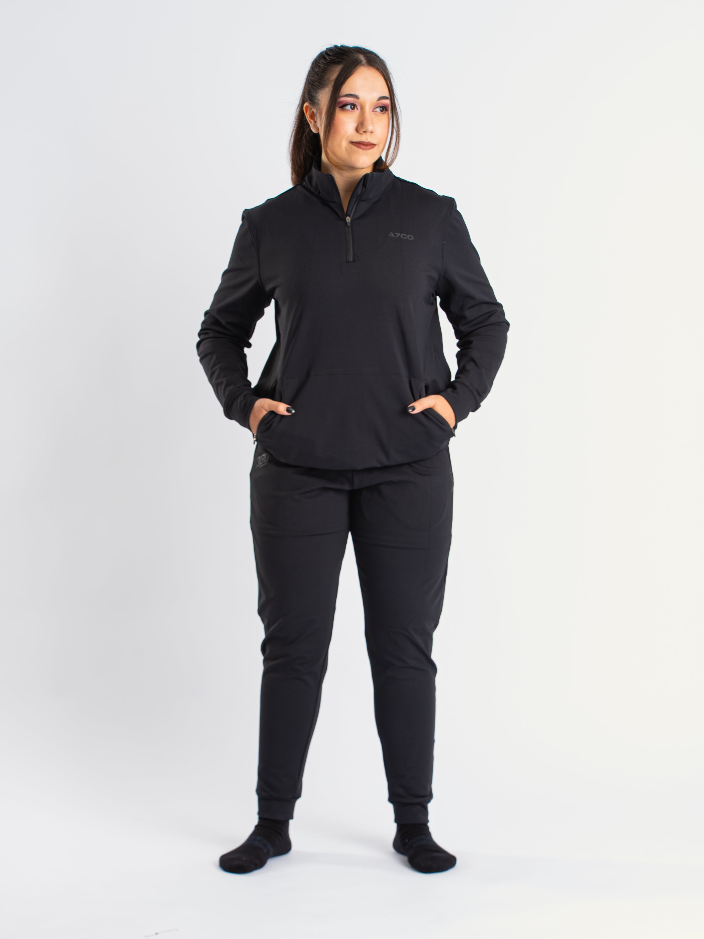 Athlete wearing the a7-us.mombra Quarter Zip Jacket in Stealth, demonstrating fit and style in a gym setting.