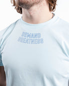 Close-up of “Demand Greatness” chest print on the Cyanite True-Fit Men’s Meet Shirt, featuring bold, textured lettering across the upper torso.