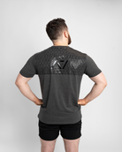 Man wearing a gray t-shirt with a7 bar grip on the back against a white background