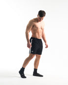 Full body image of athlete wearing A7 360Go KWD Shorts in Domino, showcasing fit, movement, and bold contrast design.